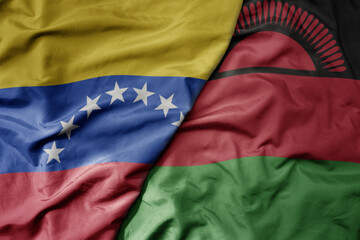 big waving national colorful flag of malawi and national flag of venezuela . macro