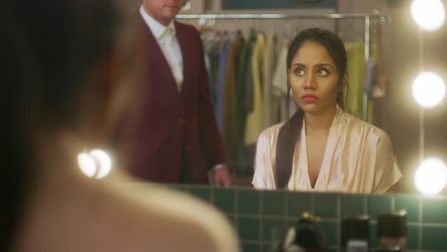 A woman looking at a cheque in a changeroom and then breaking down crying