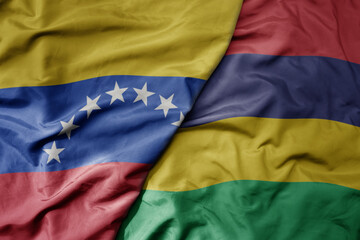 big waving national colorful flag of mauritius and national flag of venezuela . macro
