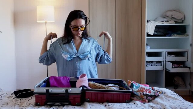 Girl going on vacation at home, putting things in a suitcase and enjoying her vacation