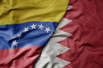 big waving national colorful flag of bahrain and national flag of venezuela . macro