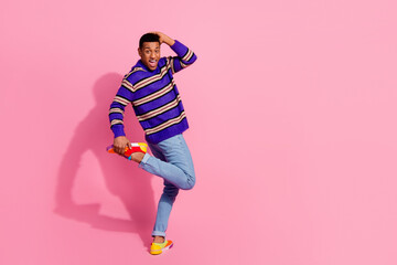 Full length photo of positive good mood guy dressed striped pullover having fun empty space isolated pink color background