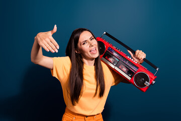 Portrait of cool hip hop artist woman wear orange t shirt dynamic moves listen rap music boombox isolated on dark blue color background
