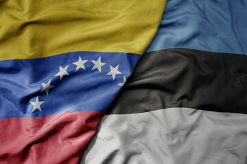 big waving national colorful flag of estonia and national flag of venezuela . macro