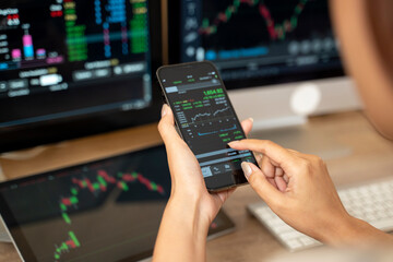 Woman is checking Bitcoin price chart on digital exchange on smartphone, cryptocurrency future price action prediction. - 726436045