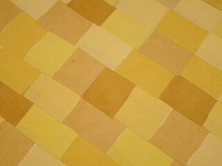 Handmade background in patchwork style with cotton fabric elements in yellow tones

