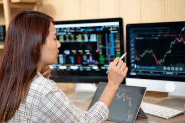 Side view businesswoman analyzing stock market investment with digital tablet.