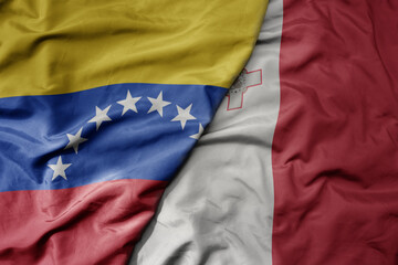 big waving national colorful flag of malta and national flag of venezuela . macro