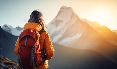 Photo sur Plexiglas Himalaya Female hiker traveling, walking alone in Himalayas under sunset light. Woman traveler enjoys with backpack hiking in mountains. Travel, adventure, relax, recharge concept..