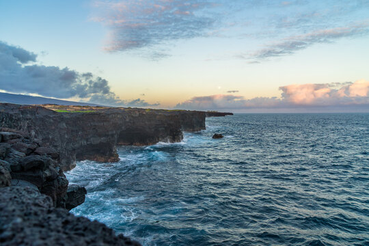 full moon during sunset over the cliffs of the volcanos on the coast of the pacific on big island in hawaii
