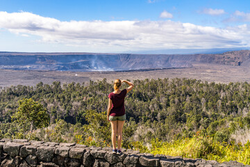 girl looks over kilauea steaming volcano on big island in hawaii