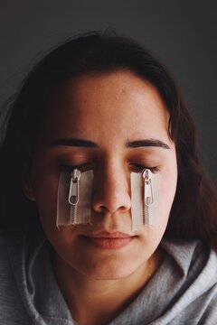 Artistic portrait of girl crying with zips on face