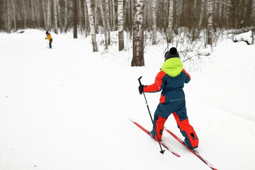 Children playing sports on a ski slope in the forest