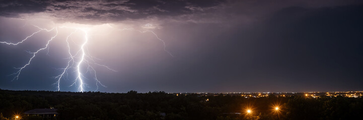 Lightning in the night sky over the city. Panorama