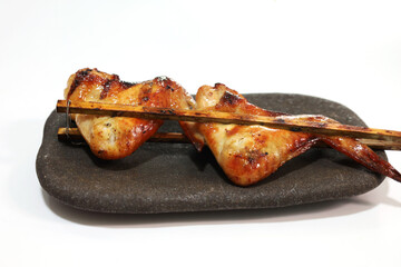 grilled chicken with bamboo sticks on white background