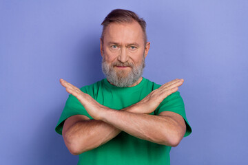 Photo of serious aged man crossed hands demonstrate stop enough gesture isolated on violet color...