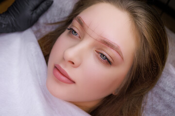 The model's eyebrows are sketched for permanent makeup. PMU Procedure, Permanent Eyebrow Makeup.