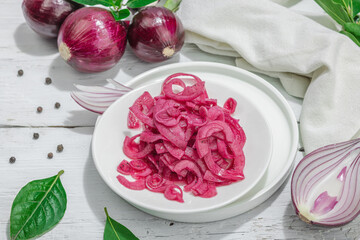 Jar with tasty pickled onions on black table. Cutlery, served meal ready to eat, trendy stand