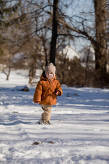 Fototapeta na wymiar Portrait of two year old boy standing in fresh snow in winter playing outdoors