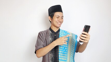 asian muslim man with holding gesture pointing towards smartphone