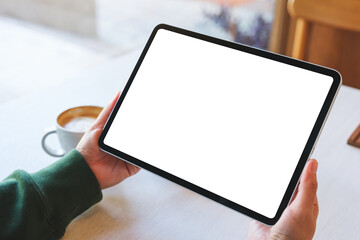 Mockup image of a woman holding digital tablet with blank white desktop screen in cafe