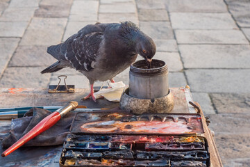 Artist's palette, paints, brushes and a dove