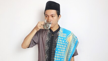 Asian Muslim man is drinking because he is thirsty