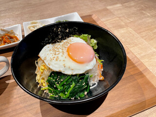 テーブルの上のトレイに盛り付けられたビビンパ（韓国料理）