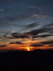 Beautiful sunset over the city. Colored clouds at sunset. Construction site at sunset. Sunset over city