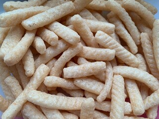 Pile of crunchy shrimp sticks as background. Close up, Crackers, snacks, crispy, sticks, kids love...