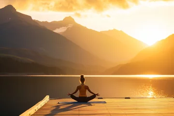 Fototapeten yoga practitioner on pier with mountain lake at golden hour © primopiano