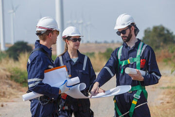 Team engineer wind turbine worker safety uniform survey discuss operational planning windmill field clean energy. Alternative technology protect environment reduce global warming problems. - obrazy, fototapety, plakaty