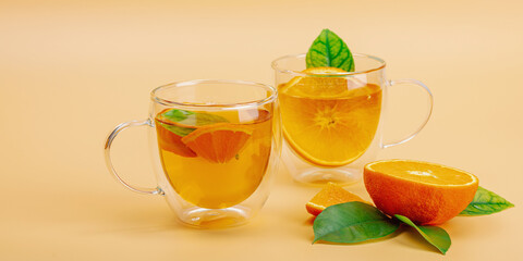 Orange tea in glass cups with ripe fruits. Refreshment seasonal drink, conceptual background