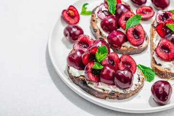 Fresh bread sandwiches with sweet cherry, cream cheese and mint leaves. Morning breakfast concept