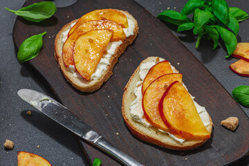 Fresh bread sandwiches with sweet peach slices, cream cheese and basil leaves. Good morning concept