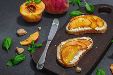 Fresh bread sandwiches with sweet peach slices, cream cheese and basil leaves. Good morning concept