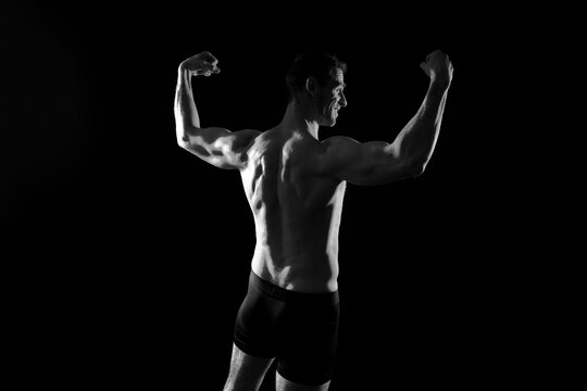 Handsome bodybuldier man posing showing muscle, shirtless torso showing pectorals and sixpack