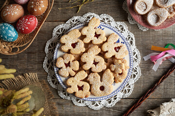 Linzer cookies in the shape of Easter bunnies filled with strawberry marmalade and dusted with sugar - obrazy, fototapety, plakaty