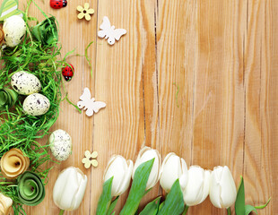 Easter composition with eggs and flowers on a wooden background
