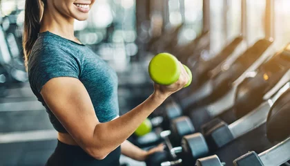 Crédence de cuisine en verre imprimé Fitness fitness woman demonstrates dumbbell exercises, showcasing determination and strength in a vibrant gym setting