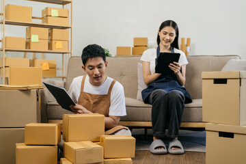 Young couple checklist with cardboard box at home - Business online and delivery concept.