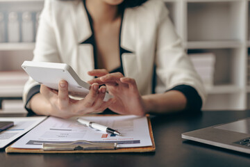 Close-up of business woman or accountant working using laptop computer to analyze business report...
