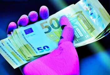 Close-up view of robot holding euro banknotes .