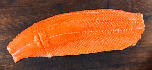 Salmon Fresh Raw Fillet on wooden board. Homemade cooking sliced salmon, serving food for restaurant, menu, advert or package, close up, selective focus