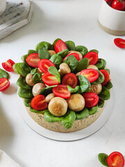 Gourmet herb-crusted quiche topped with vibrant greens and cherry tomatoes.