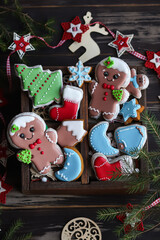 Colorful Christmas gingerbread cookies with icing, displayed among holiday decor.
