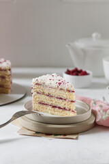 Elegant red velvet cake slice with sprinkles, on a neutral-toned table setting.