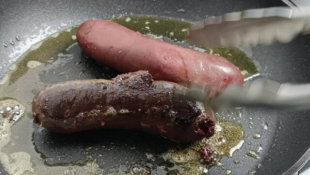 deux boudins noirs, en cuisson, dans une po&ecirc;le