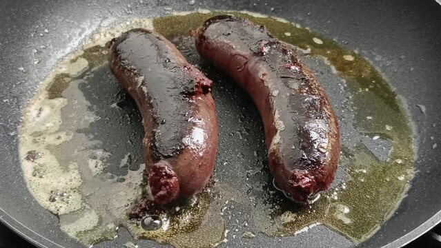 deux boudins noirs, en cuisson, dans une po&ecirc;le