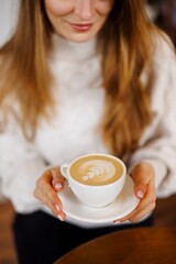Closeup of a beautiful woman drinking cappuccino